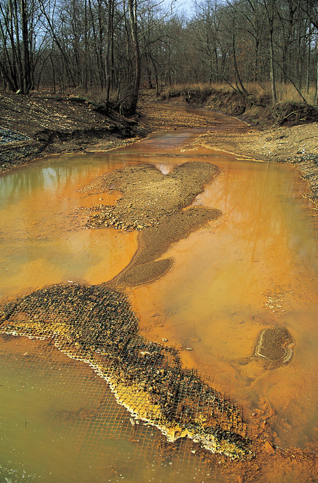 Rusty colored stream contaminated with toxic substances due to acid mine drainage