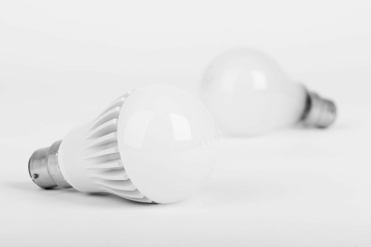 B&W closeup of LED light bulb with incandescent lightbulb in the background