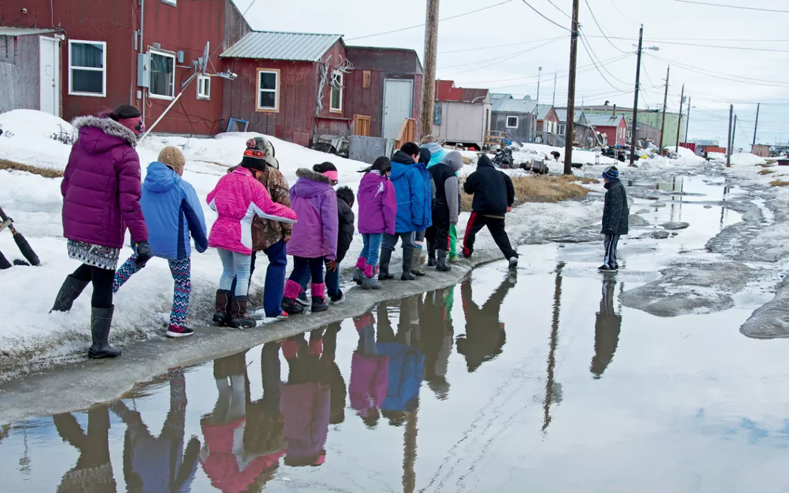Dodging puddles during "breakup" (when the snows melt) in Shishmaref, Alaska