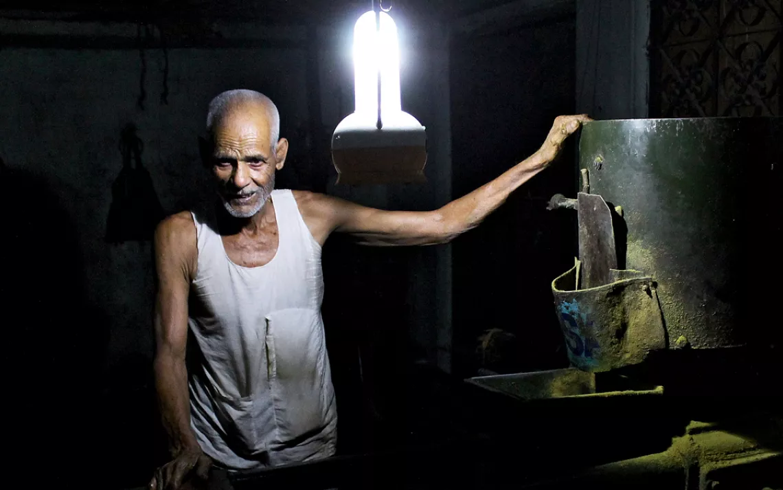 A mustard grinder works by the light of a solar-charged lantern.