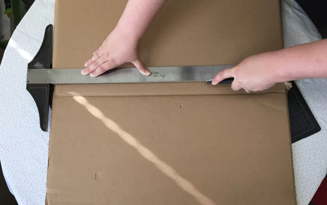 Use the utility knife to cut off the bottom flaps of the box. 