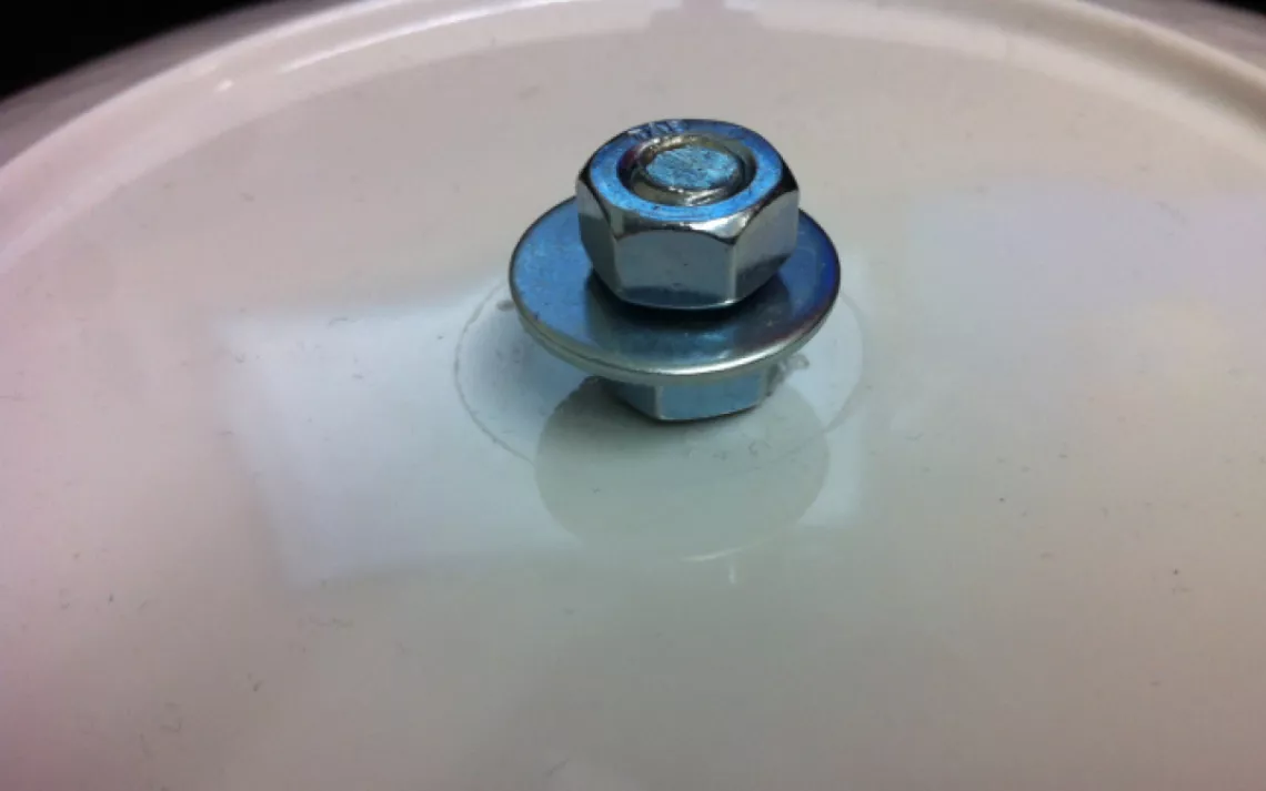 Slip a washer onto the top nut. Then screw on the third nut.