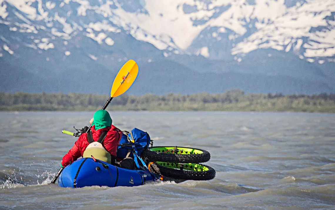 Ryan Krueger's wheels, rigged onto his packraft, are lapped by the Dangerous River