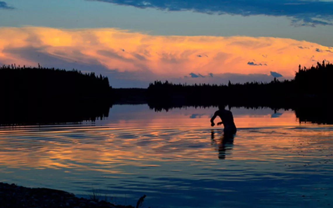 Retreating thunderclouds, a fiery sunset, and an evening swim on the Attawapiskat River
