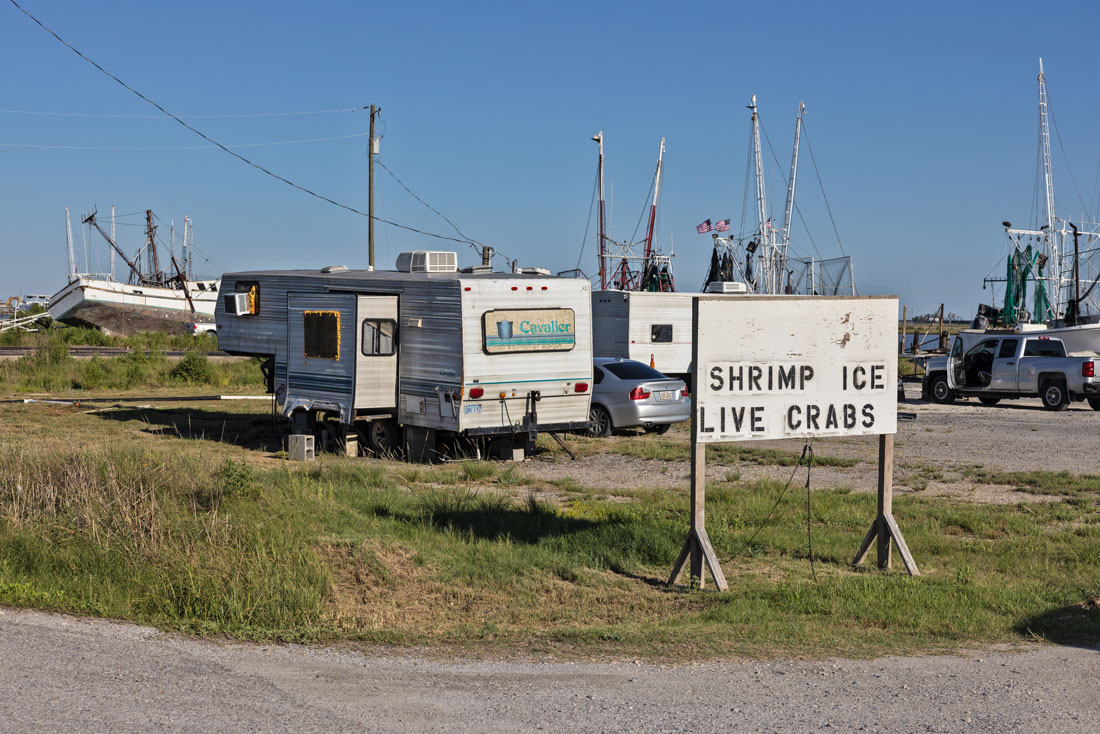 A trailer with a sign reading “Shrimp Ice Live Crabs”