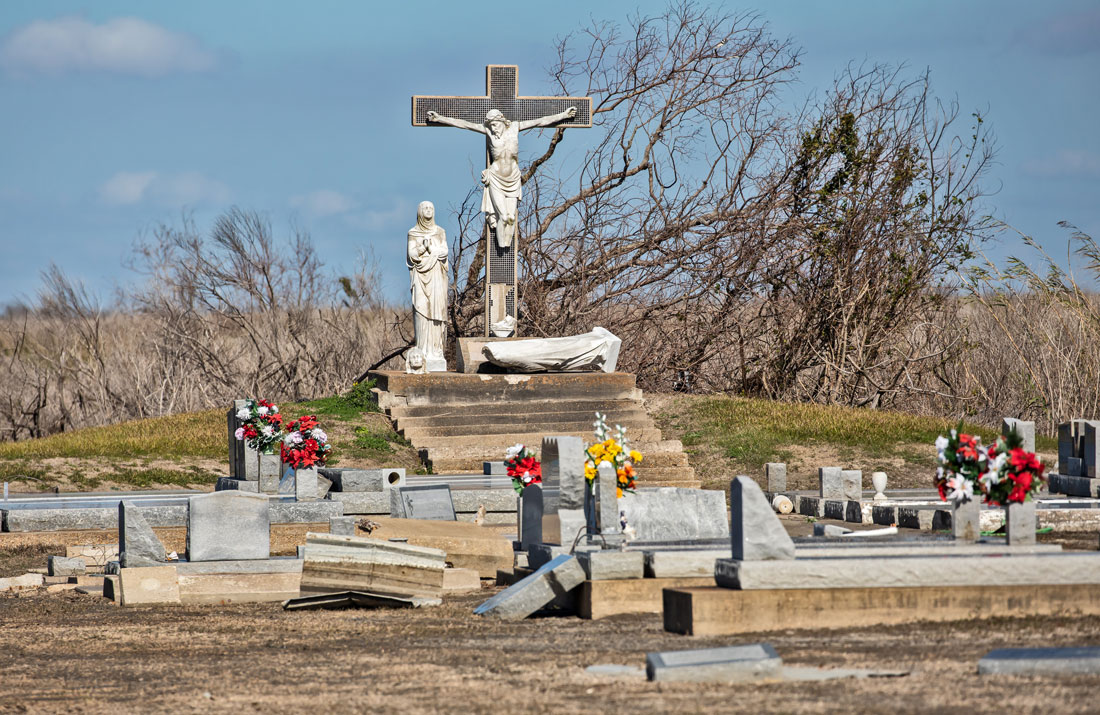 Cemetery in Cameron with Christ on a Cross overlooking headstones.