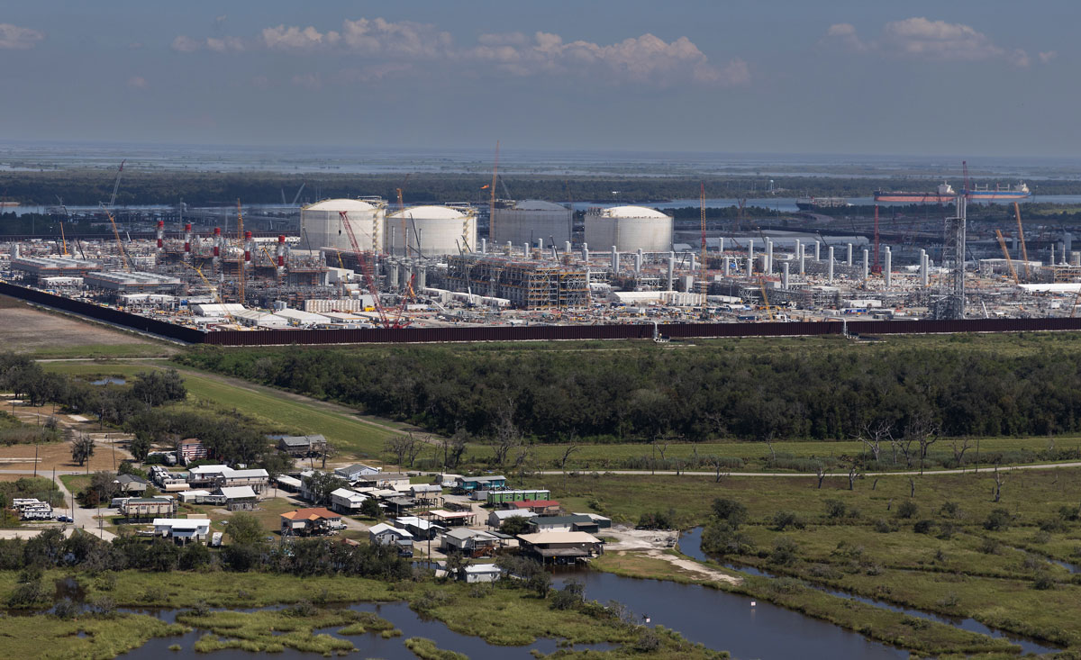 Aerial view of an LNG terminal rising behind a residential community in Plaquemines Parish, Louisiana.