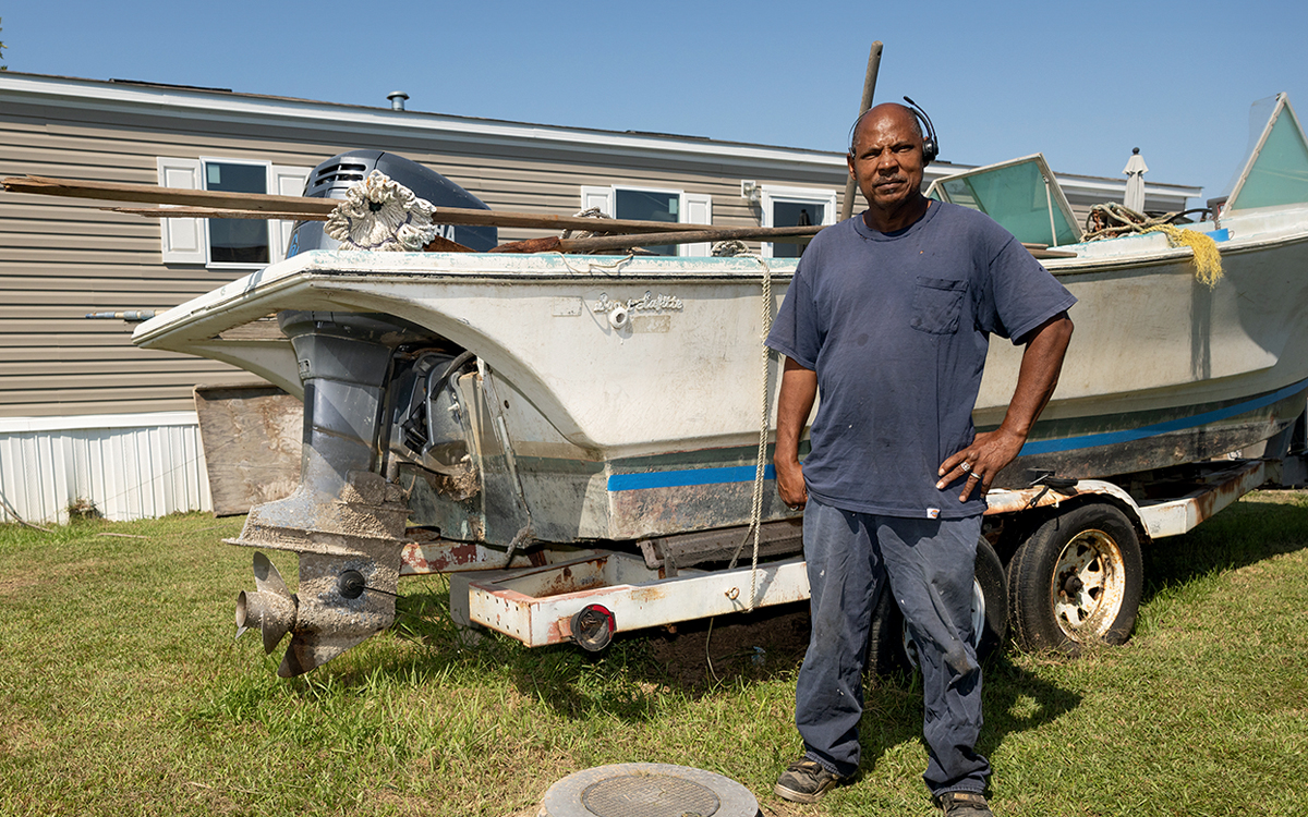 Solomon Williams standing by a boat.