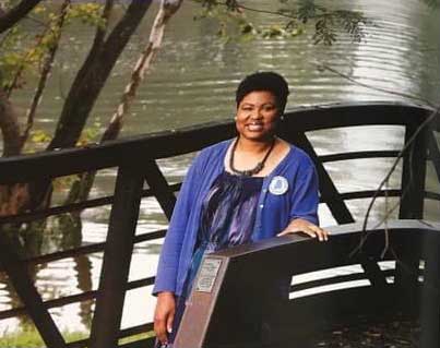 photo of Dr. Kenya Goodson standing on a bridge with water in the background