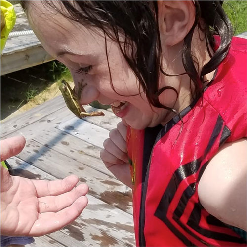 young girl enjoying nature--frog on her nose