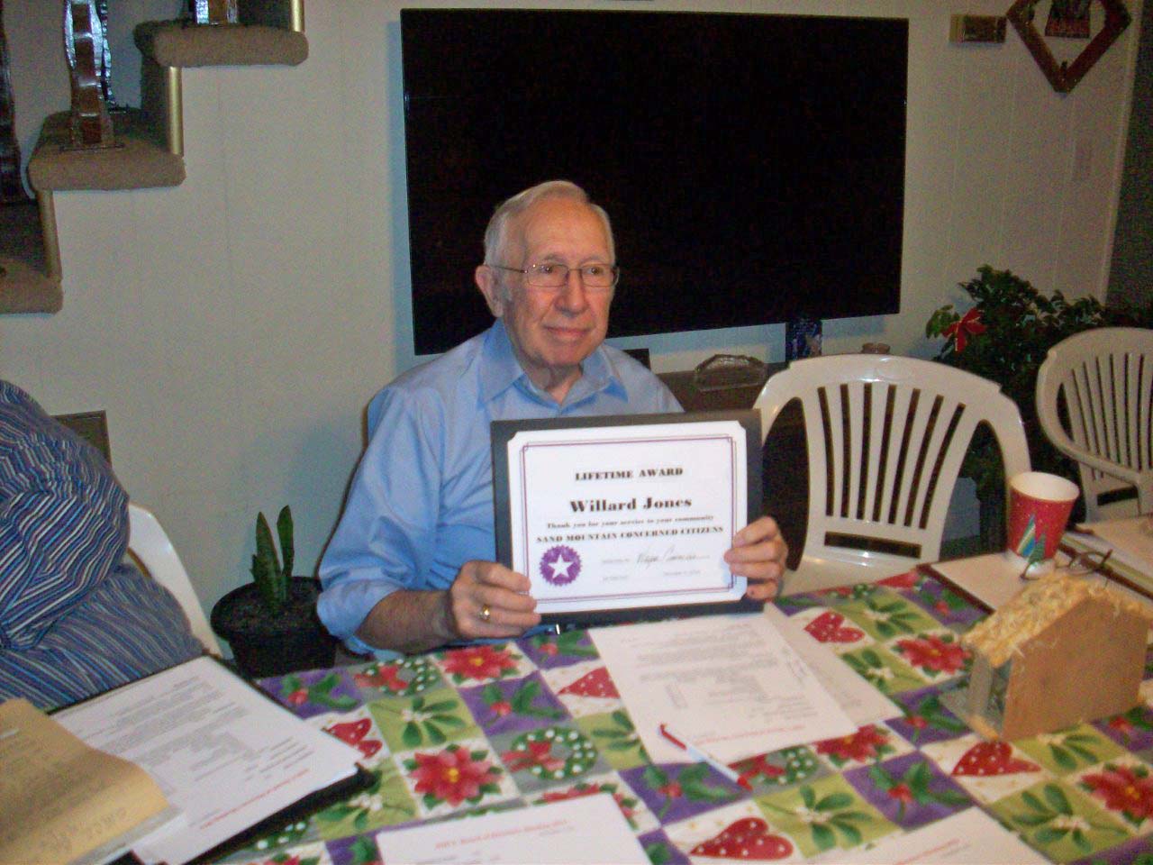 Willard Jones holding up a lifetime achievement award