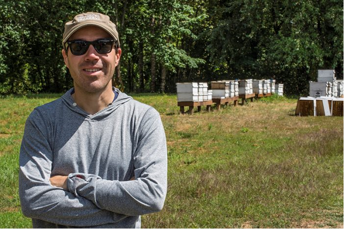 Kieth Seiz with several hives in the background.