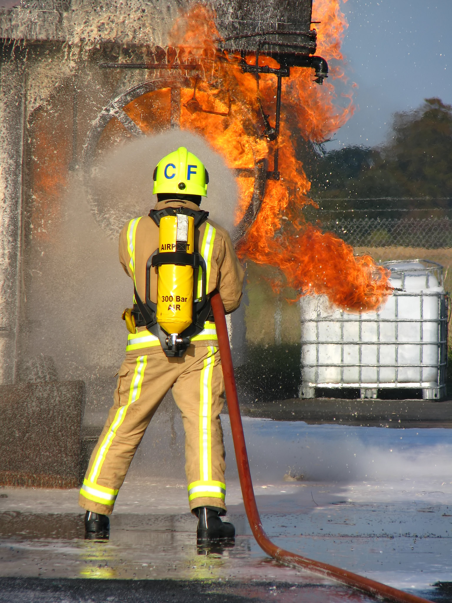 A firefighter uses foam spray to put out a blaze.