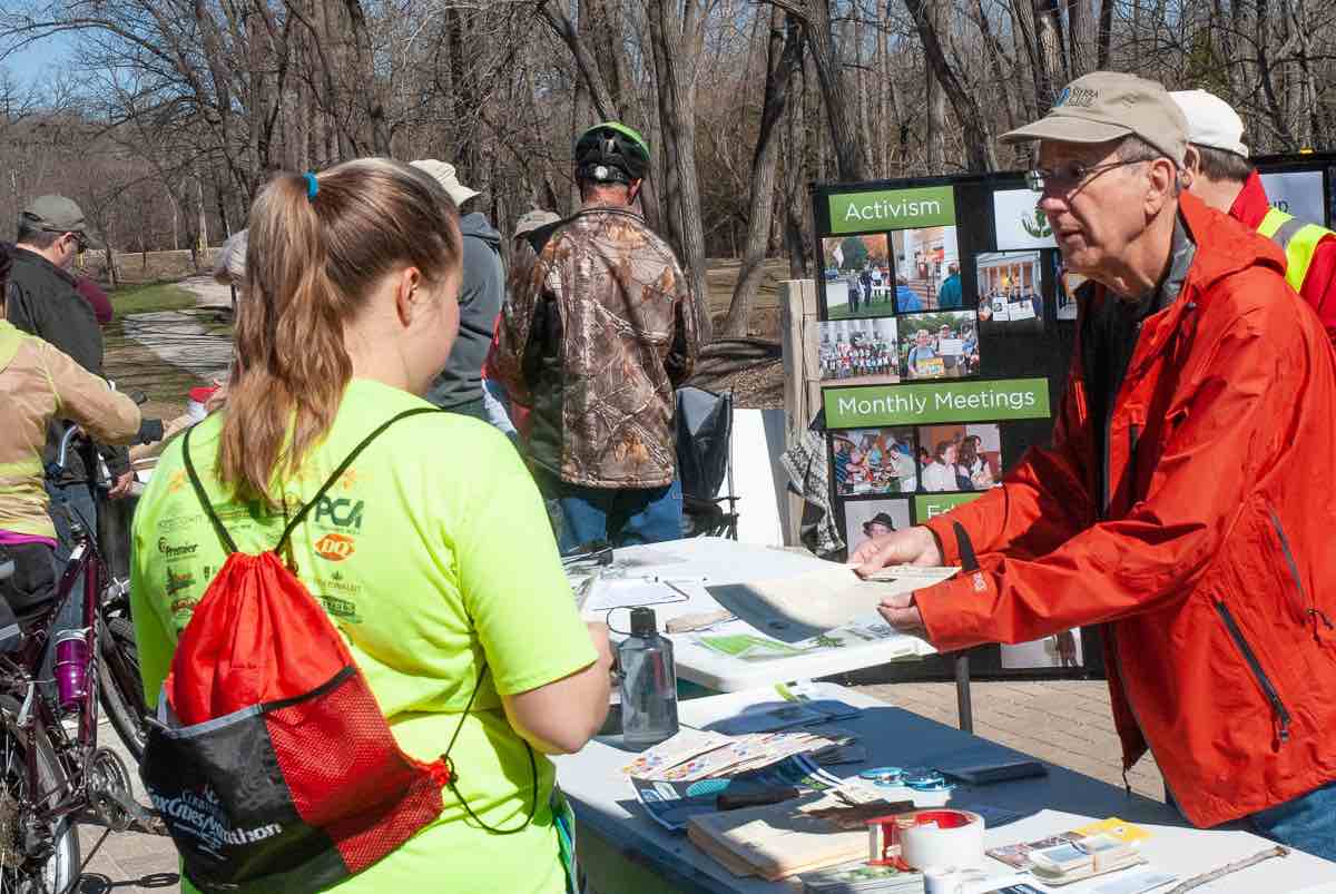 A volunteer shares information with a participant at the Sierra Club table.