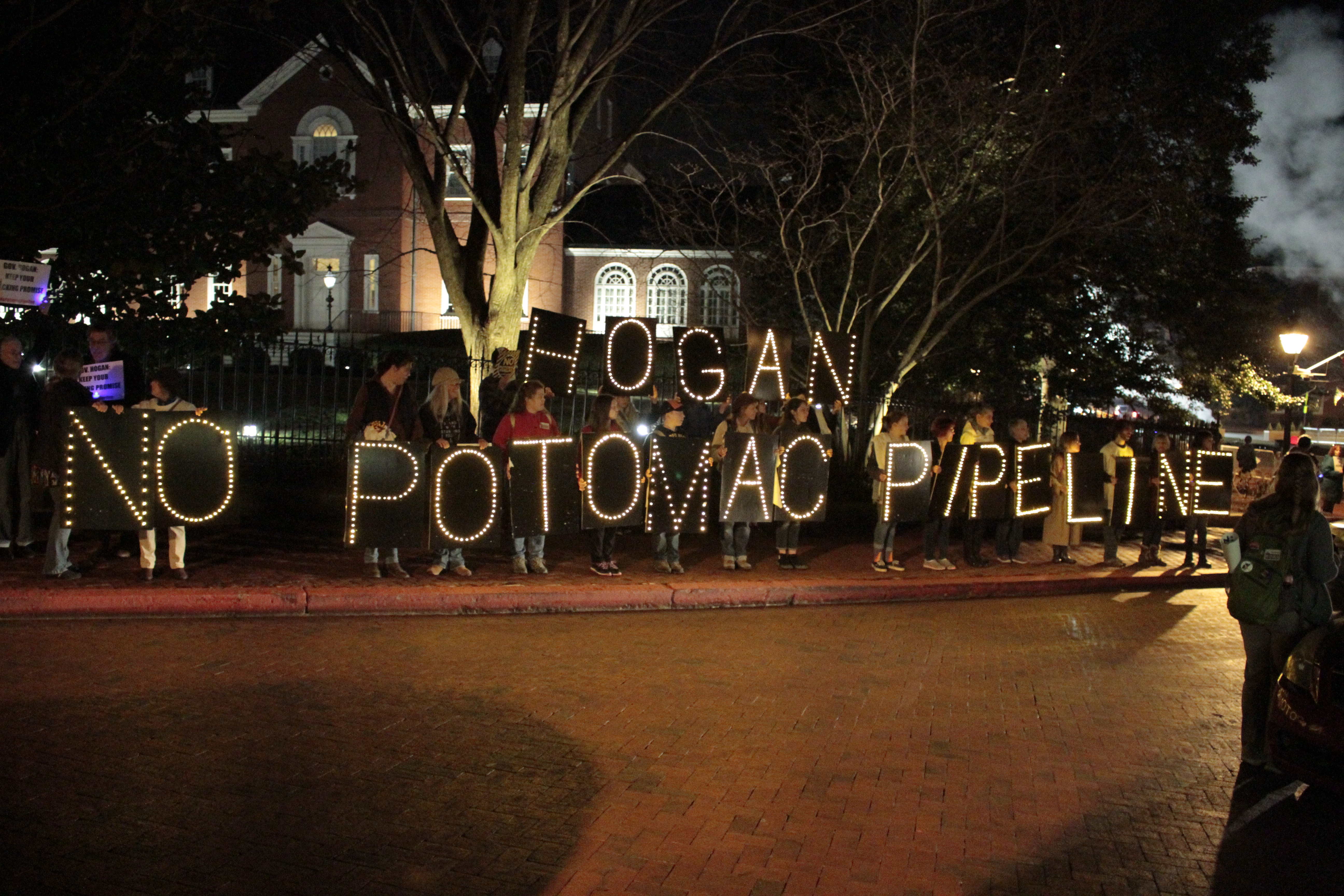 Group holding signs reading "Hogan No Potomac Pipline" outside Governor's Mansion