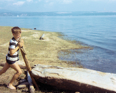 Young Nick moving a log at a lake