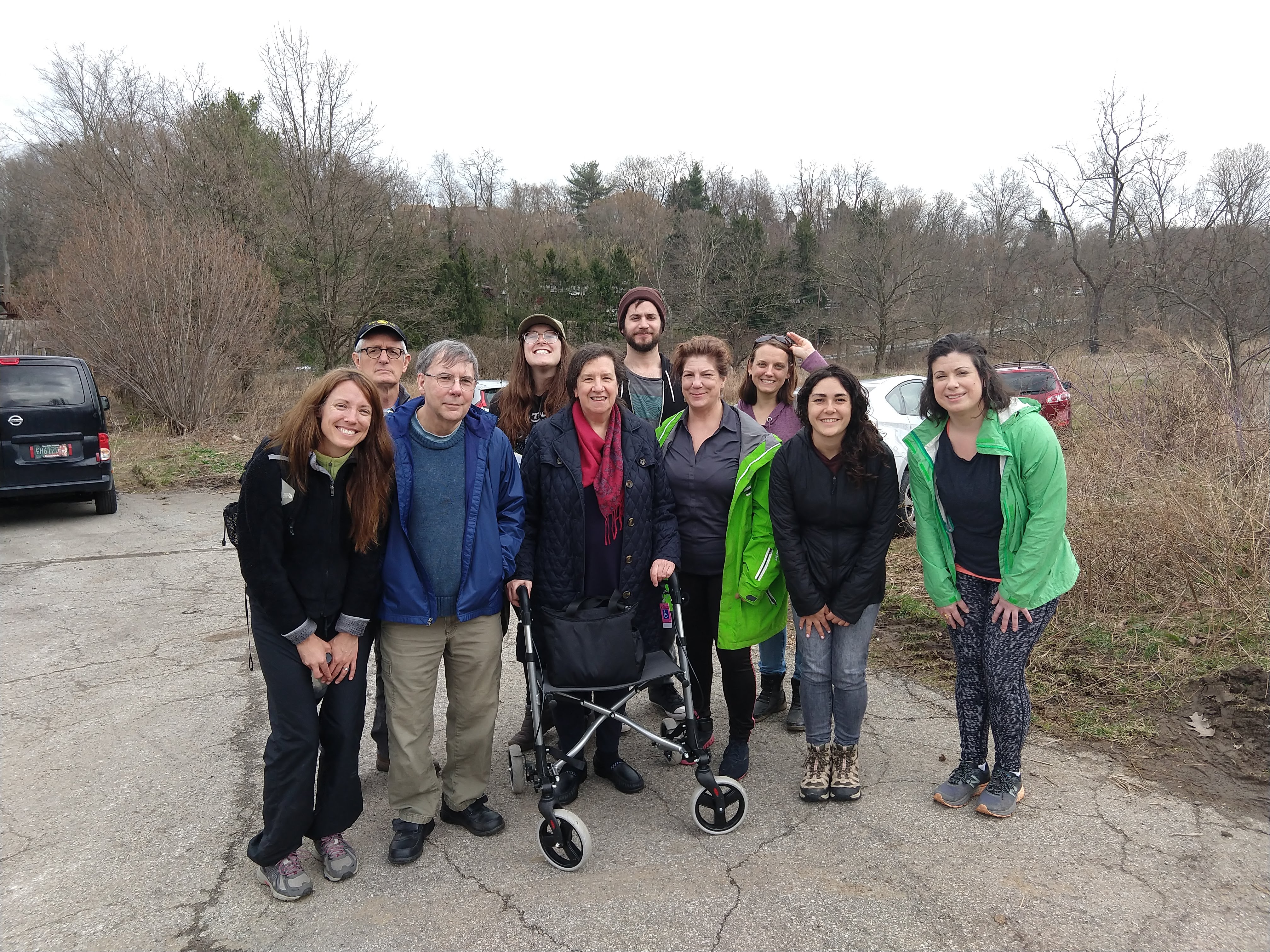 A group of hikers gathers in the parking lot at Churchill Valley Country Club for a group photo.