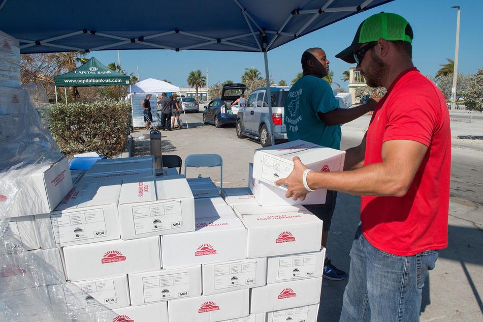 Shane Vansant (right) and Joshua Howard hand out food to Hurricane Irma survivors at a supply distribution point in Key West, Florida on Monday, September 18, 2017. Photo by J.T. Blatty / FEMA