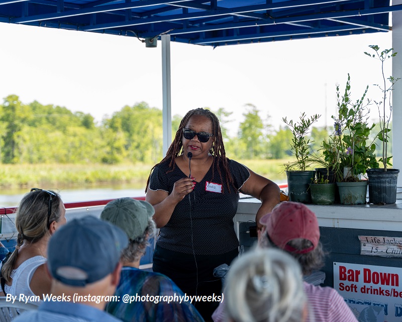 Community activist Anita Cunningham speaks to guests on a Cape Fear River cruise boat about wood pellet production's environmental impact on communities near factories