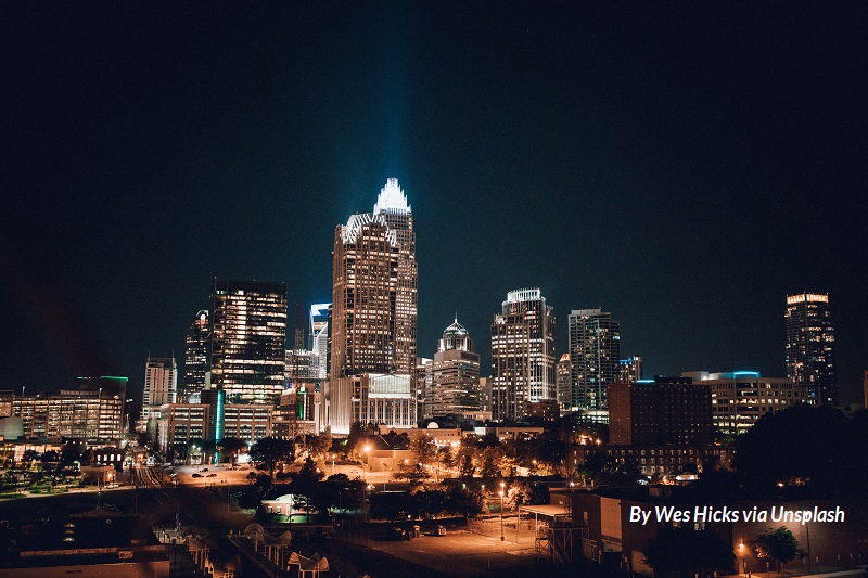 The skyline of Charlotte, NC, at night, with lights blazing in skyscraper windows