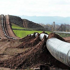 Stock image of a new gas pipeline being laid across fields and hills