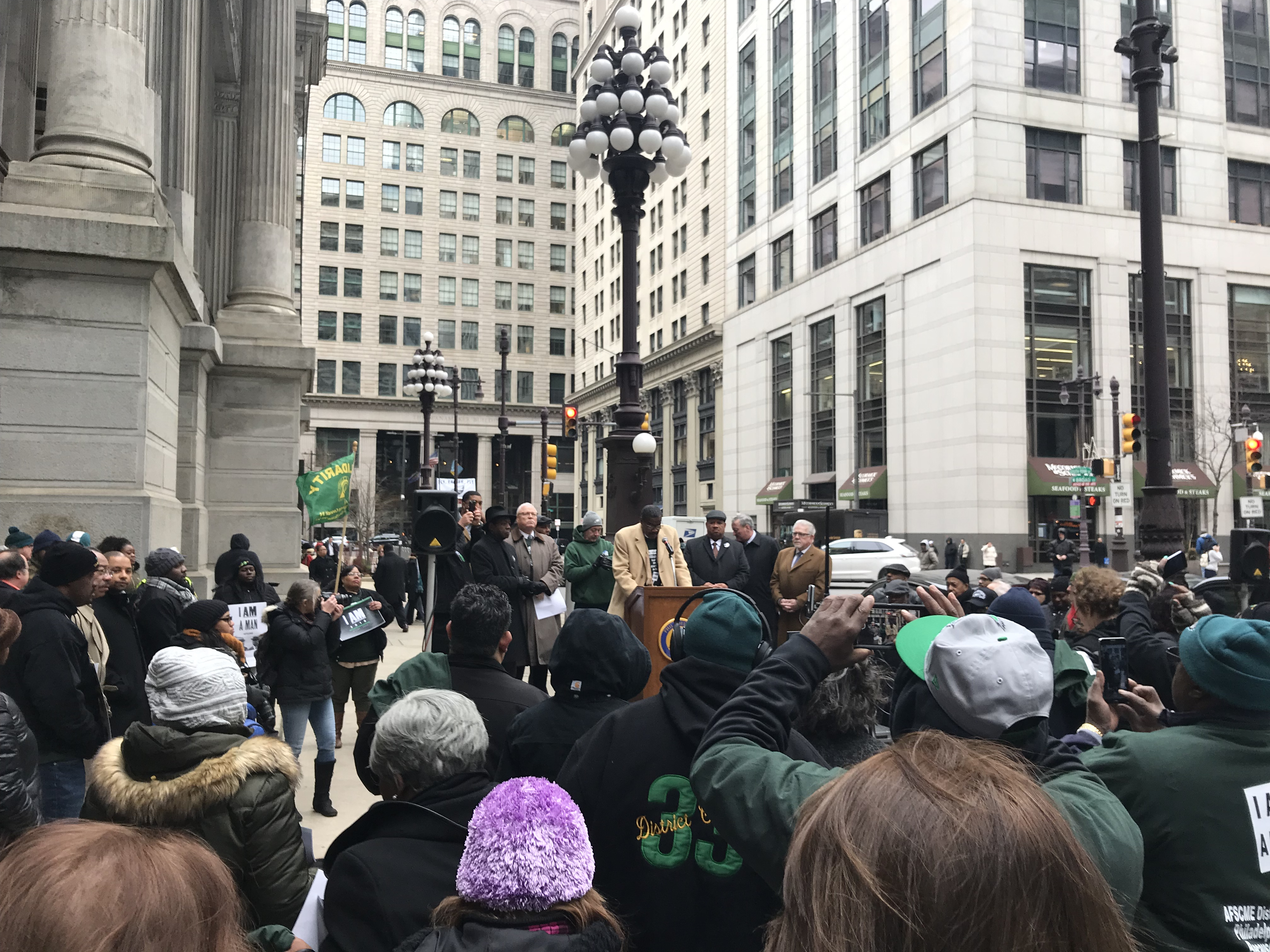 A crowd gathers in front of City Hall as AFSCME DC 33 President Pete Matthews speaks.