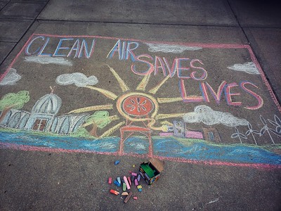 Sidewalk chalk that says "clean air saves lives" with a chalk drawing of Madison