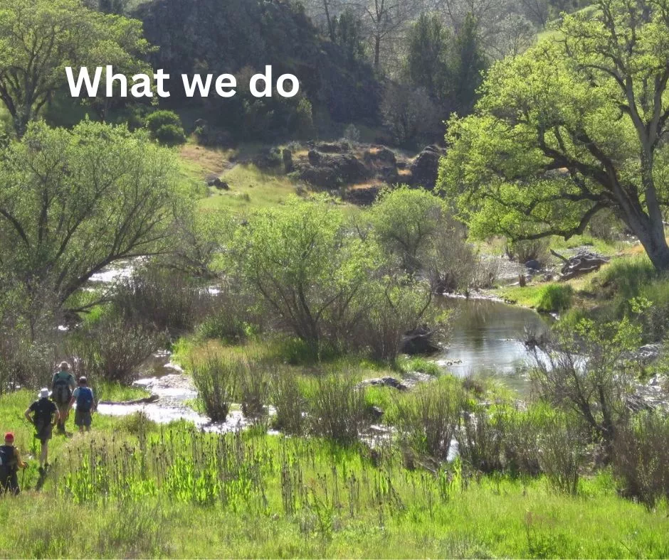  Text What we do on top of hikers in a green valley with water,