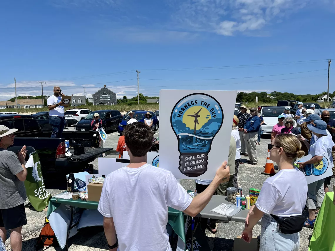 Person holds up "Cape Cod is Ready for Offshore Wind" sign at rally.