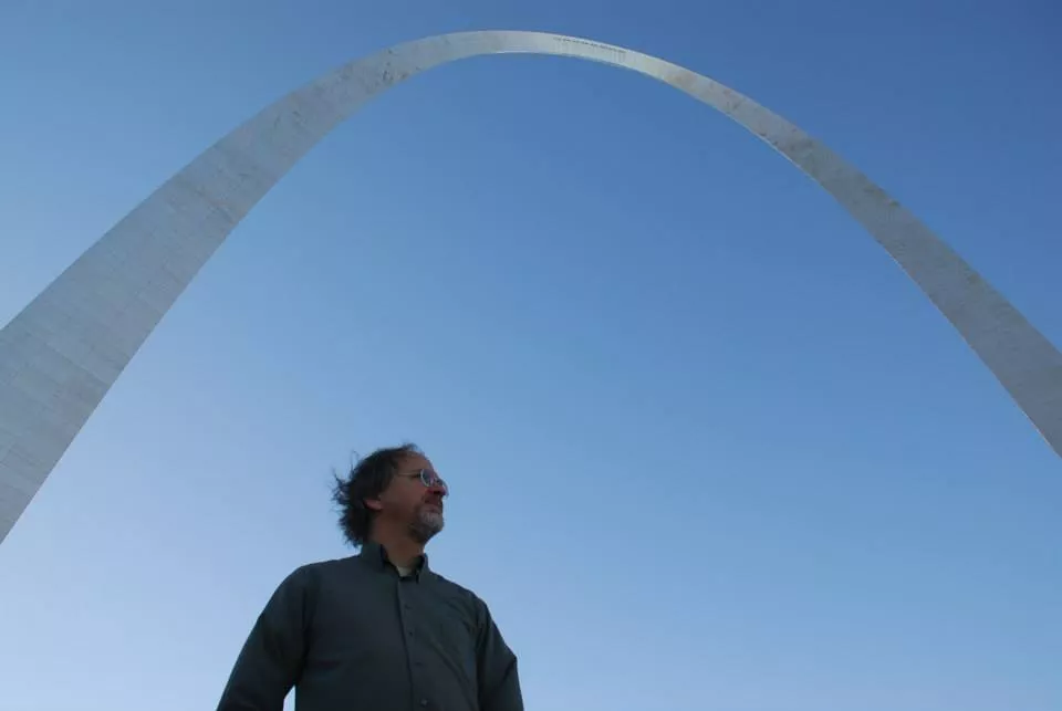 Andy is standing below the St. Louis Arch