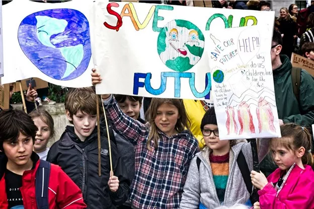 children holding up colorful posters with save our earth messaging