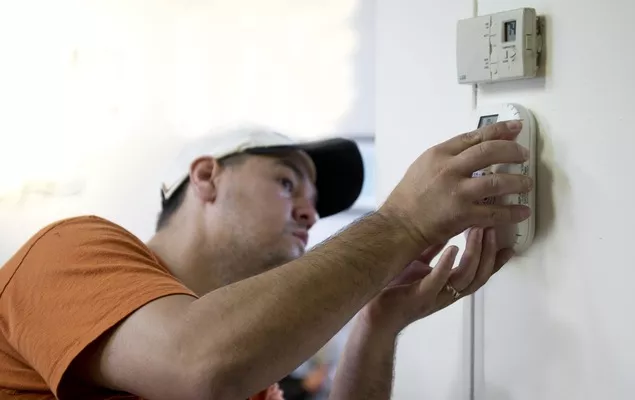 New home thermostat being installed