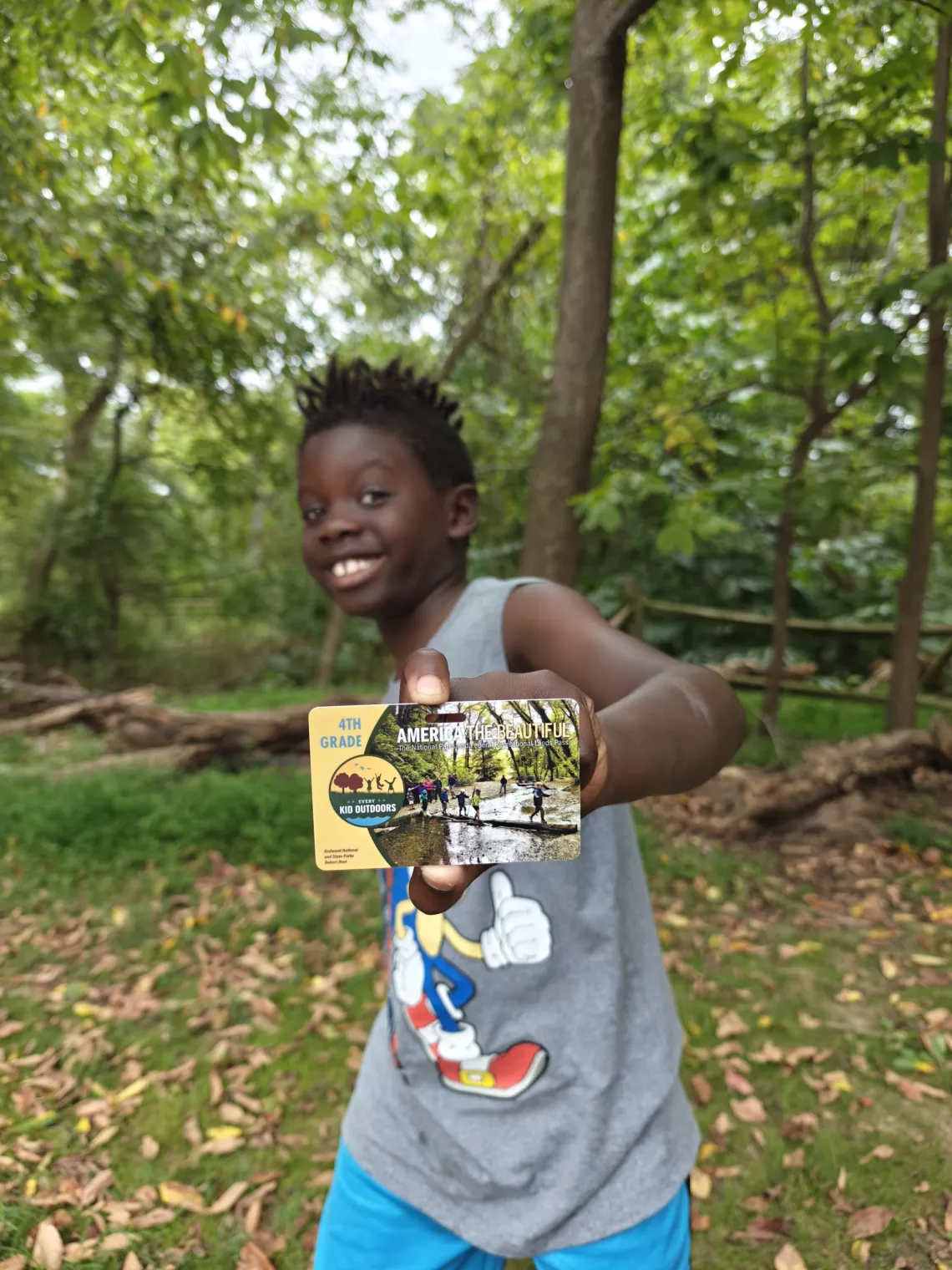 A boy poses with his Every Kid Outdoors pass