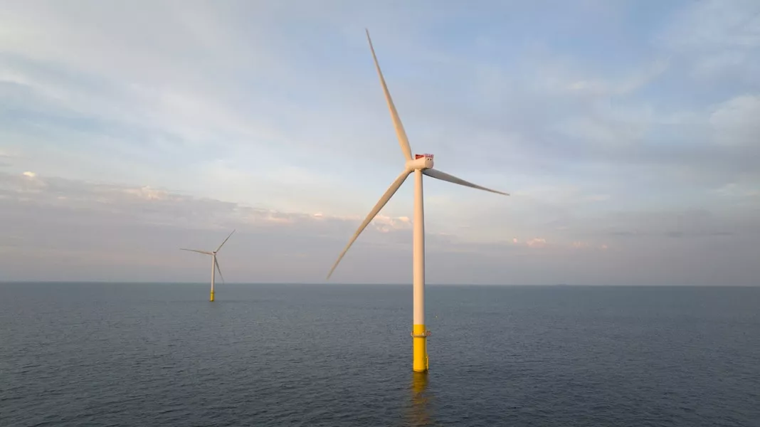 A photograph of two offshore windmills in the open ocean.