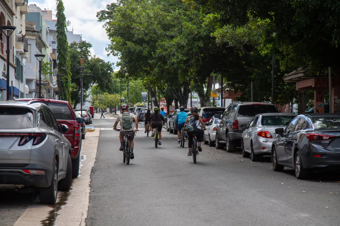 a group of people biking down a road