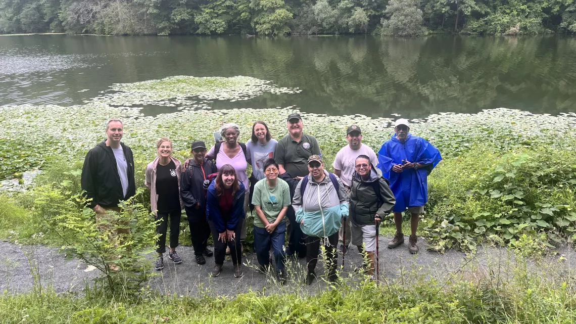 A group of people pose by a body of water