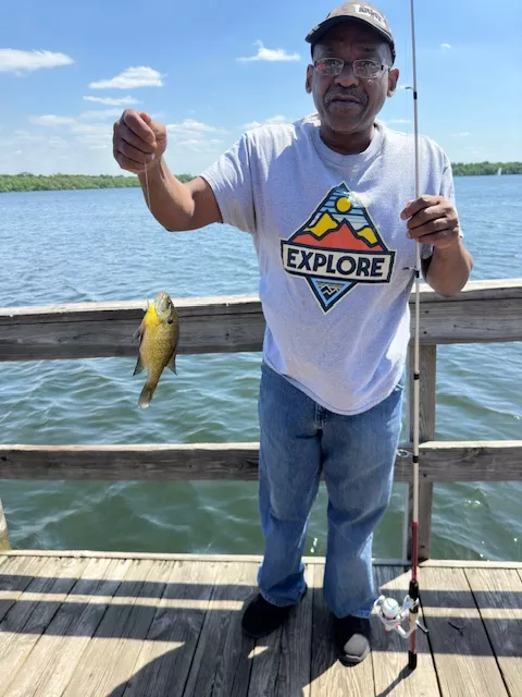 A man holds up a fish on a fishing line