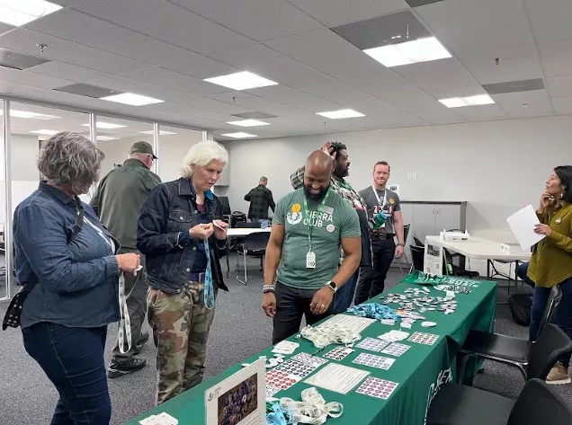 Three people look at a display table