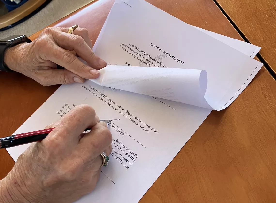 hands signing a will