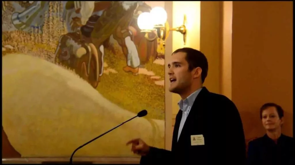 young White man in suit speaking at microphone in Kansas House of Representatives