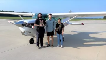 2023 Summer Fellows Chandler Allred, Logan Steinike and Tashi Choden are shown in front of a small plane in which they flew over CAFOs in Eastern North Carolina. Image by Erin Carey
