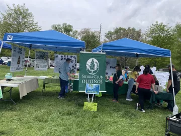 Two blue tents with the Sierra Club Outings Flag between them.