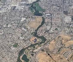 View from above of a meandering stream in a big city