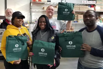 Image of Anne Arundel Group Chair with volunteers holding up Sierra Club reusable bags. 