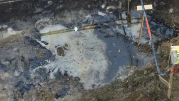 Oil coats a pit of soil in an image captured of the Enbridge spill in Cambridge, WI.