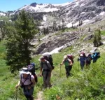 Hikers with backpacks, snow-capped mountains in back