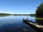 A dock out onto a lake bordered by trees