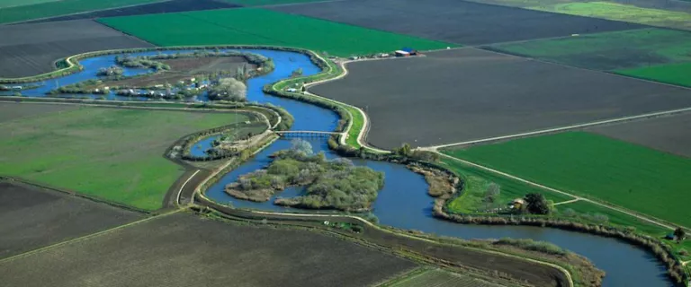 Color photo of the a river and green fields