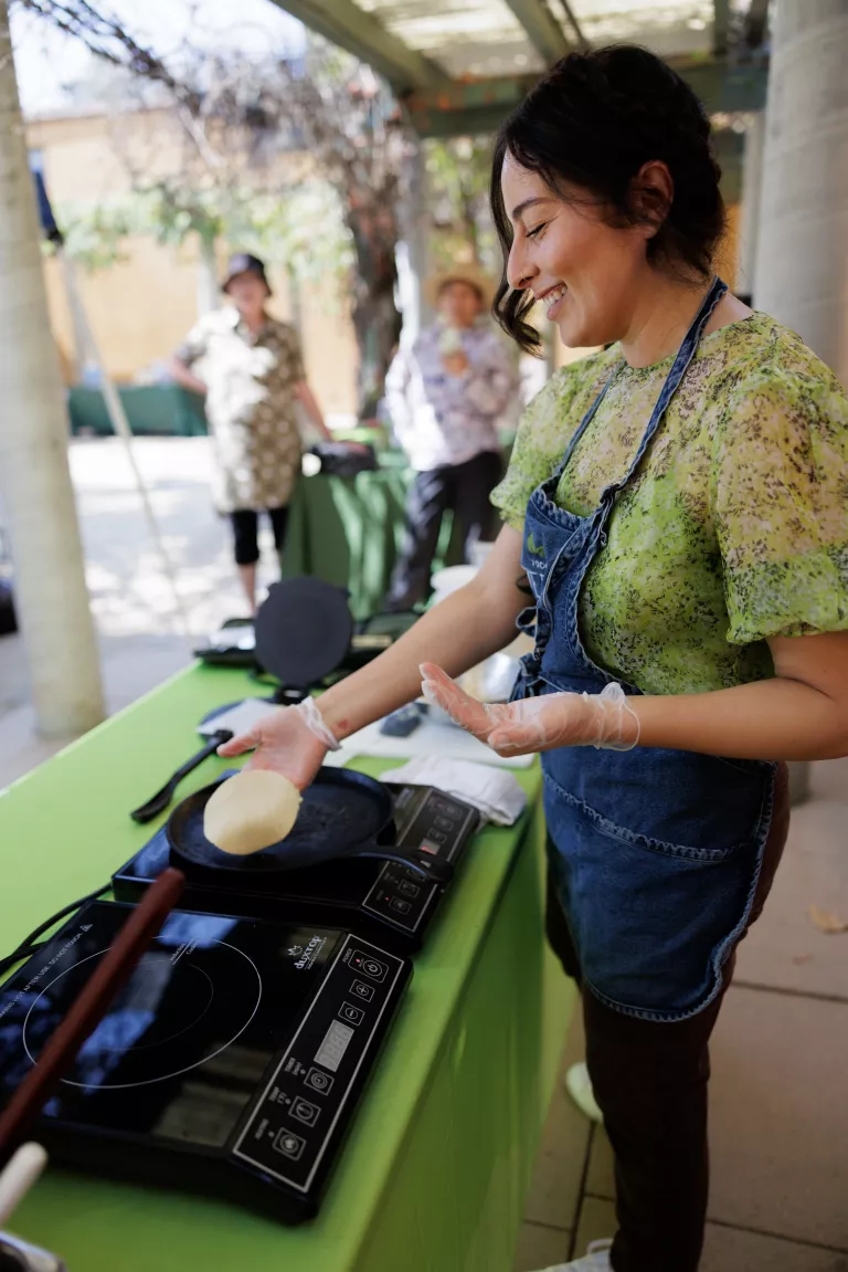 Woman cooking tortillas on an induction stove