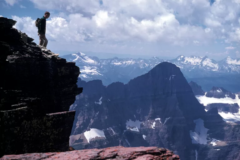 Hiker gazes out at a panoramic view from the summit of Mount Gould in Glacier National Park